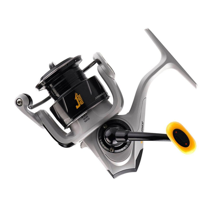 A close-up of a silver and black fishing reel with a yellow accent on the handle. The reel has sleek, modern design details and a visible brand logo on its side.