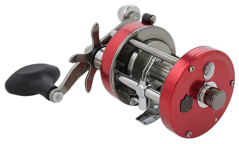 The Abu Garcia Ambassadeur 7000C 4.1:1 Round Casting Reel features a red and silver finish, black handle, metal components, and open spool design, displayed against a white background.