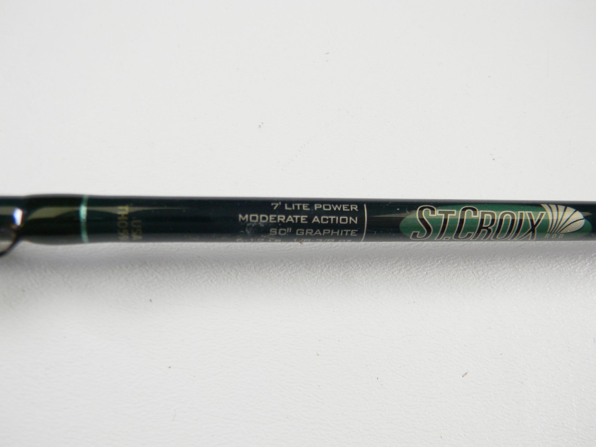 A close-up of a St. Croix Tidemaster TIC70LM 7'0" Light Used Casting Rod in excellent condition, suitable for the Rod and Reel Trade-In Program, with "ST. CROIX" and product details visible on the rod.