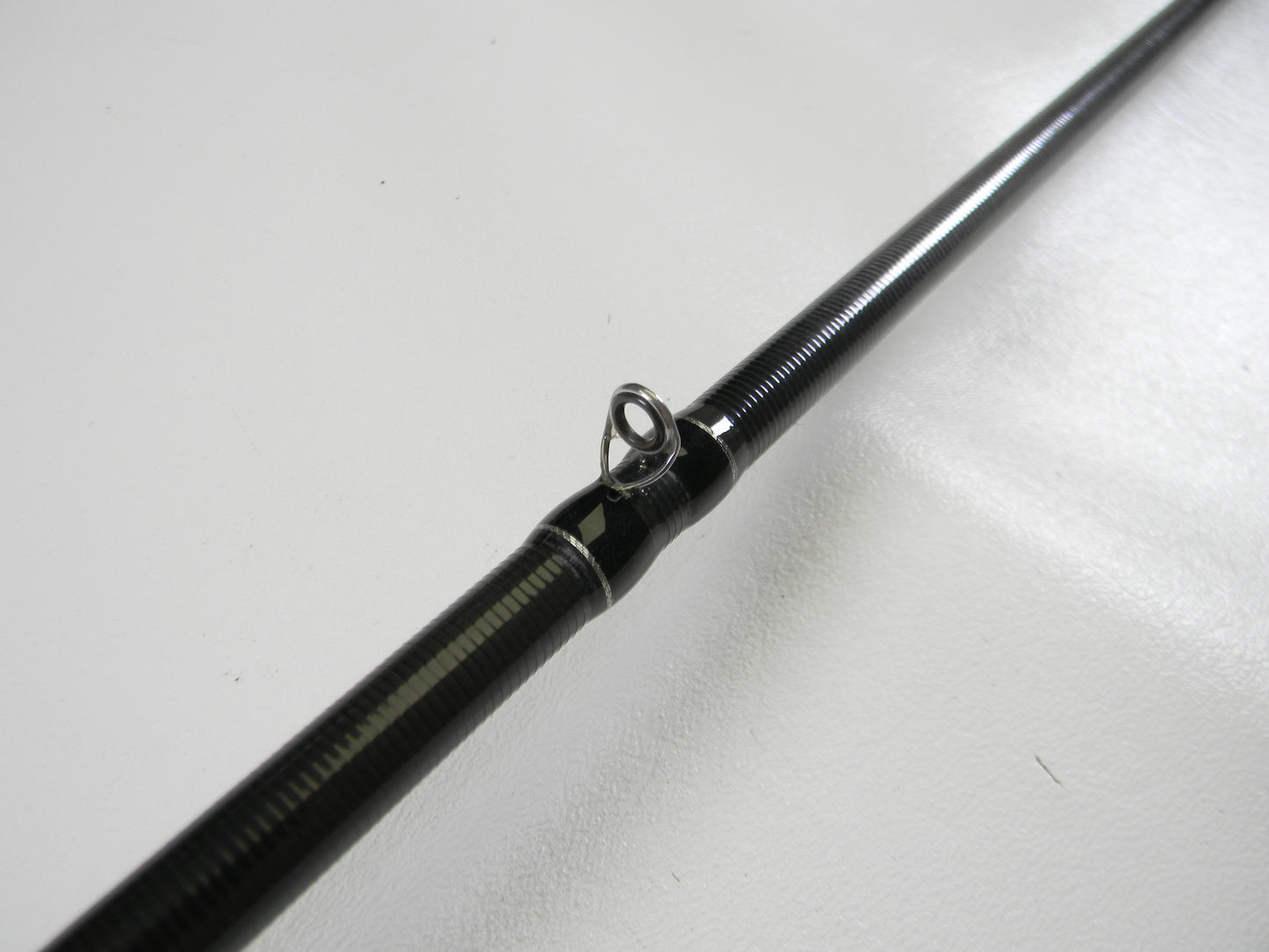 Close-up of a Duckett Black Ice DFBI80MH-CC 8'0" Medium Heavy Crankin' Casting Rod in excellent condition, features a black finish with line guide, set against a plain white background. Consider our Rod and Reel Trade-In Program for valuable store credit on used gear.
