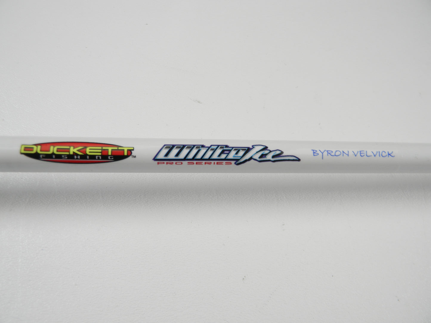 Close-up of a Duckett White Ice DFWI711HC Casting Rod, featuring "Duckett Fishing" and "White Ice Pro Series" logos, with "Byron Velvick" printed in blue on a plain white background. The rod is part of the Rod and Reel Trade-In Program.