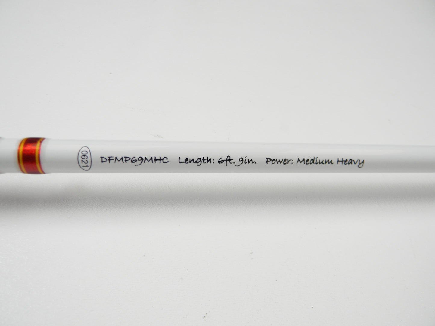Close-up of Duckett Micro Magic Pro DFMP69MHC, 6'9", Medium Heavy. The rod has a white surface with red accents and is ideal for the Rod and Reel Trade-In Program's quality used gear seekers.