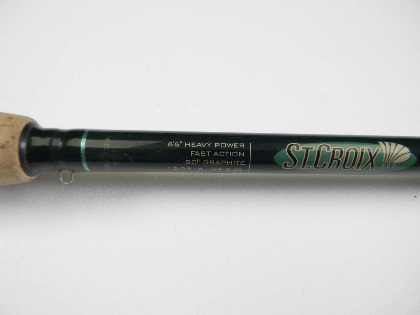 Close-up of a St. Croix Tidemaster TIC66HF casting rod, featuring a cork handle and black body. The text reads: "6'6" Heavy Power, Fast Action, SCII Graphite." Upgrade with our Rod and Reel Trade-In program and earn store credit while enjoying St. Croix quality.
