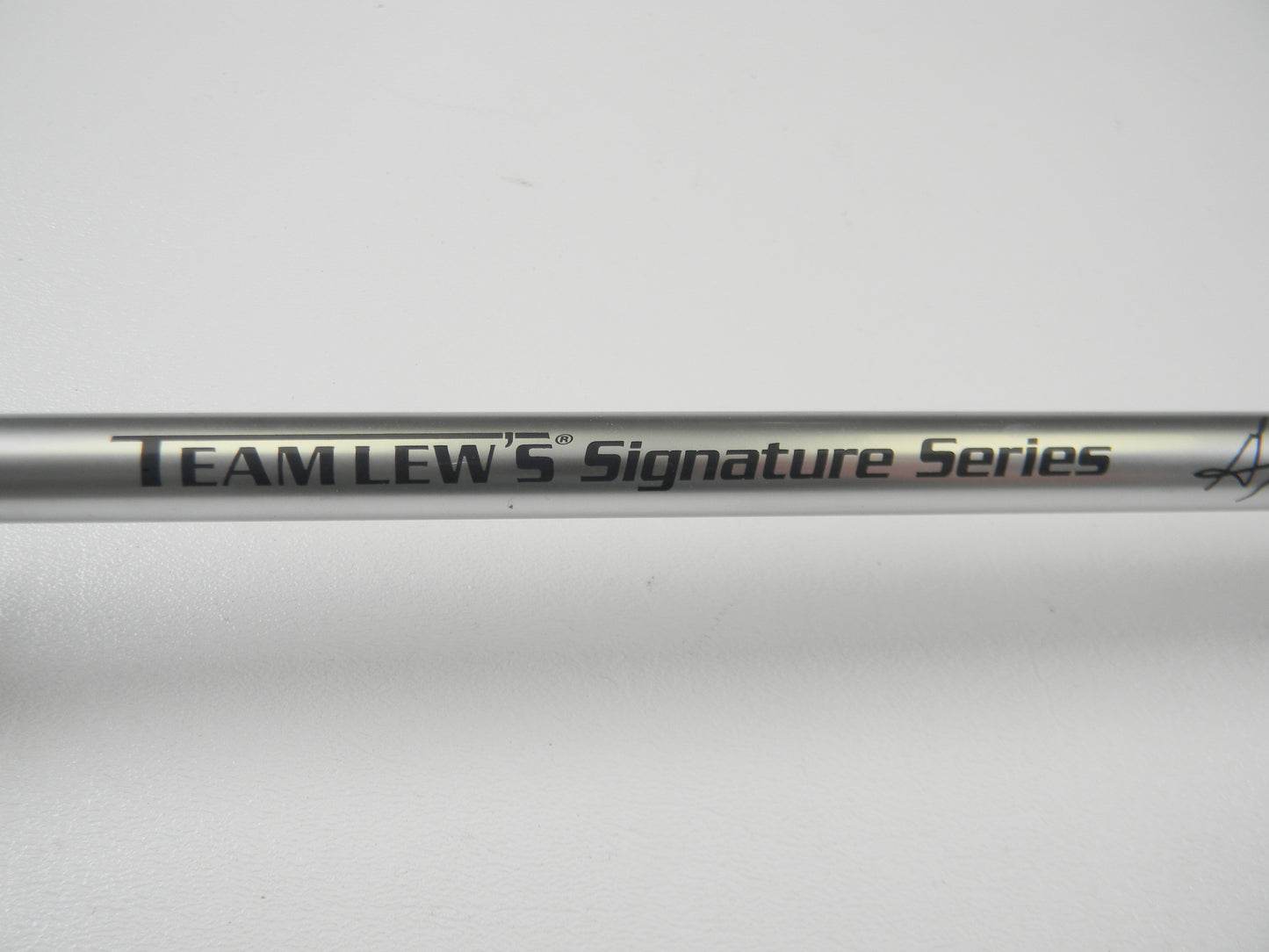 Close-up of a Lew's Signature Series TLS73H Frog 7'3" Heavy Casting Rod in excellent condition, featuring black "Team Lew's Signature Series" text on a metallic finish. Ideal for Rod and Reel Trade-In, the plain white background highlights its sleek design and pristine performance.