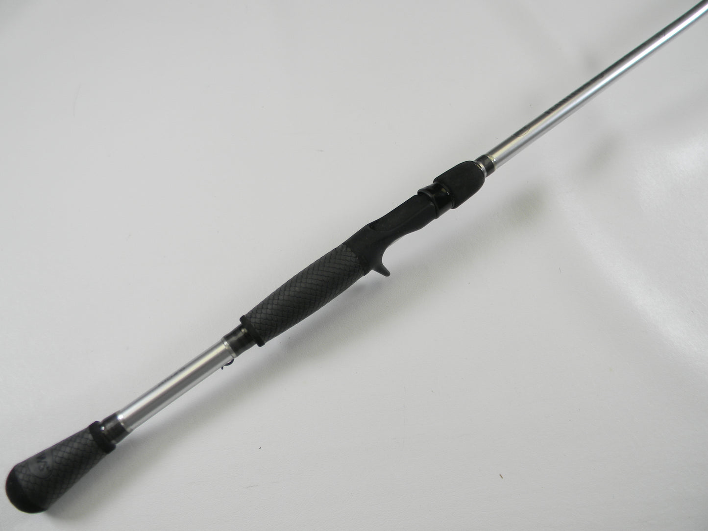 The Lew's Signature Series TLS76H Pitching 7'6" Heavy casting rod, with its black textured grip and sleek silver shaft, lies on a white surface, ready for your next adventure. Use our Rod and Reel Trade-In Program to exchange used gear for store credit and enhance your fishing experience.