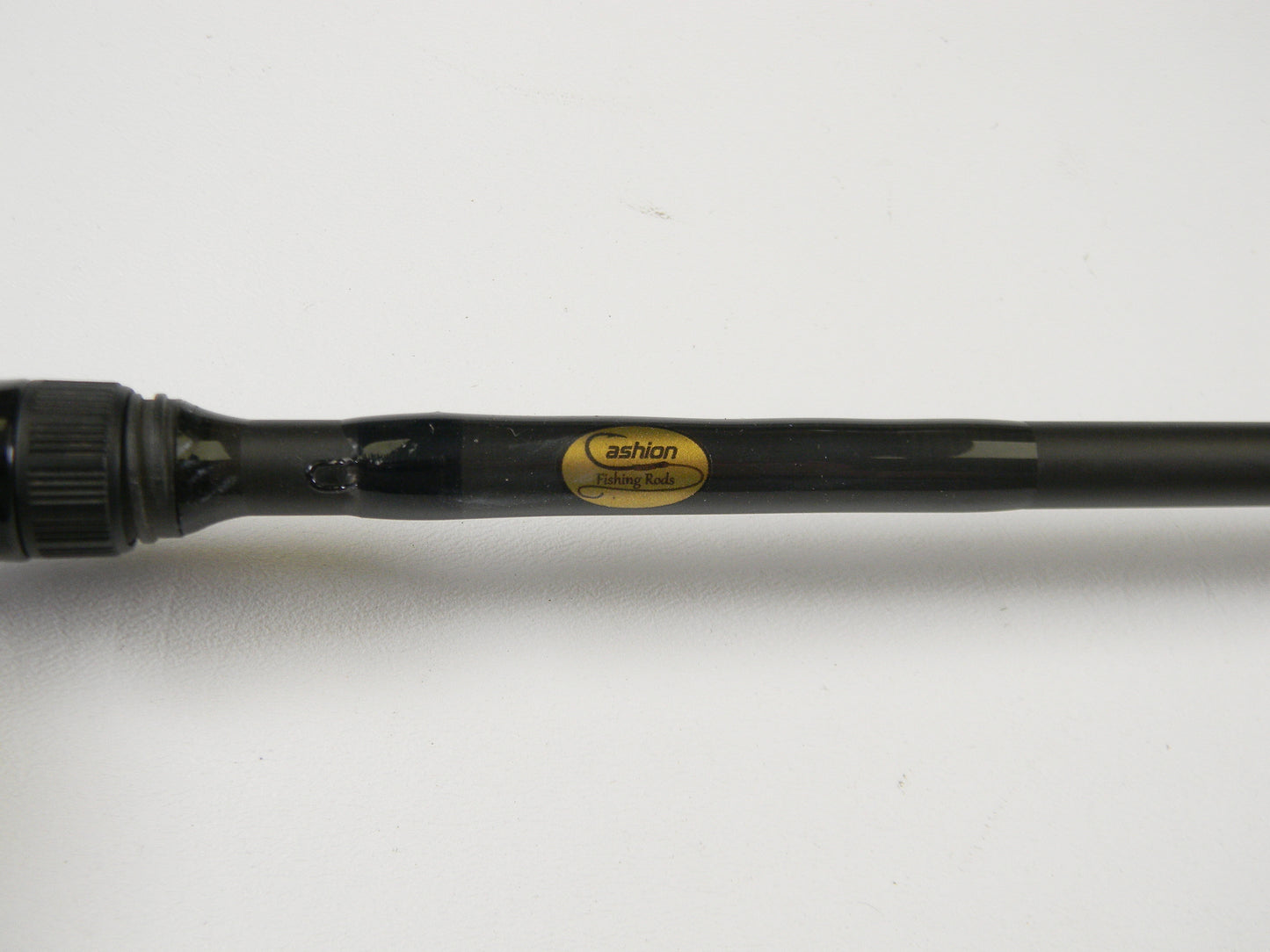 Close-up of a black fishing rod labeled "Cashion" on a white background, featuring the Cashion F90474b 7'4" Medium Heavy - Used Casting Rod in very good condition, ideal for upgrades through our Rod and Reel Trade-In program.