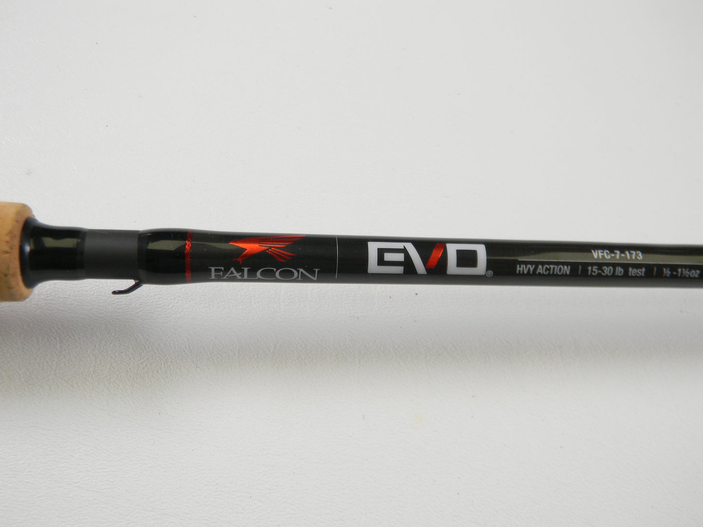 Close-up of the Falcon EVO VFC-7-173 7'3" Heavy casting rod with "HVY ACTION" and line weight details. It features a cork grip and sleek black finish, ideal for upgrading anglers. Qualifies for Rod and Reel Trade-In Program to earn store credit on used gear.