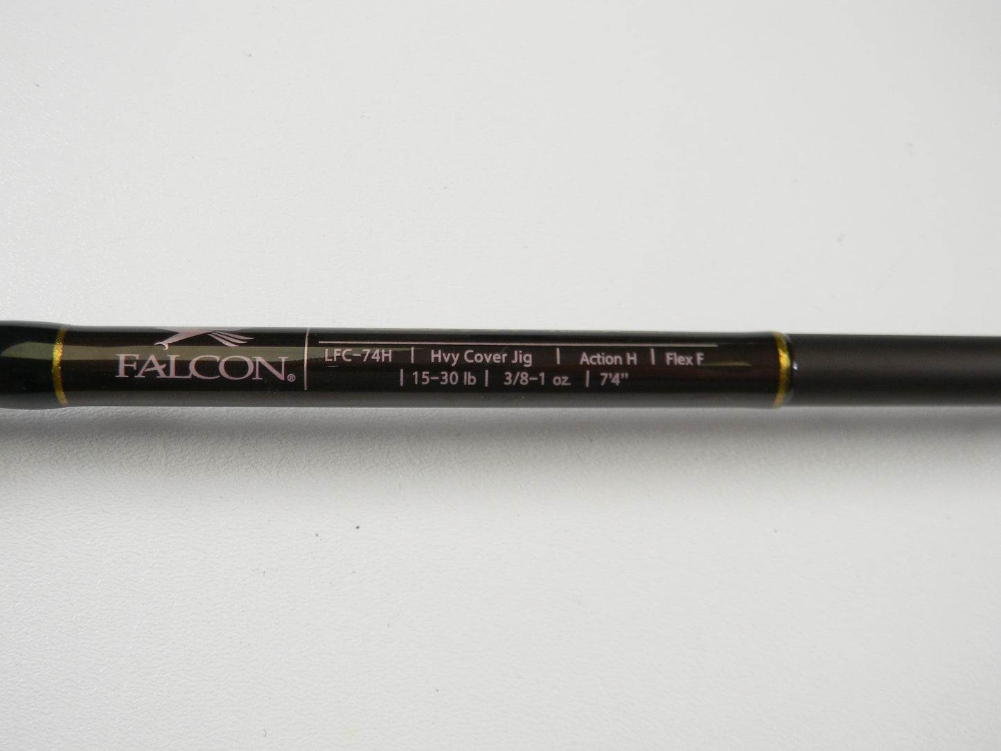 Close-up of Falcon Lowrider LFC74H Heavy Cover Jig: 7'4", black with yellow accents, "15-30 lb," handles "3/8-1 oz," Action H, Flex F. Consider upgrading via our Rod and Reel Trade-In Program for store credit.