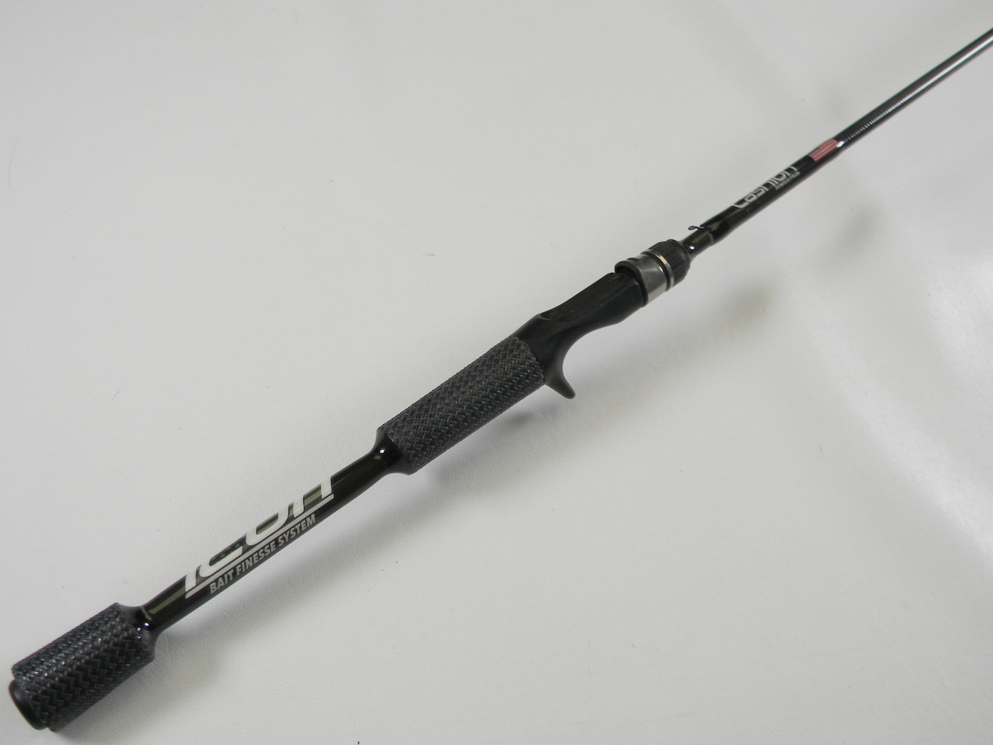 A black and silver Cashion Icon Series iBFS610MLF 6'10" medium light casting rod with a textured grip and sleek, lightweight design is shown diagonally against a white background. Perfect for the Rod and Reel Trade-In Program or earning store credit through our used gear condition process.