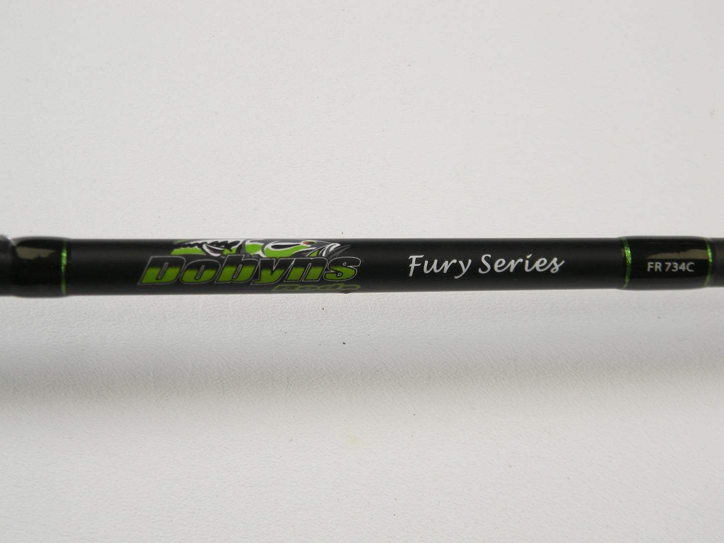 Close-up of a black Dobyns Fury FR734C Used Casting Rod with green accents, displaying the text "Dobyns Fury Series FR 734C" against a white background.