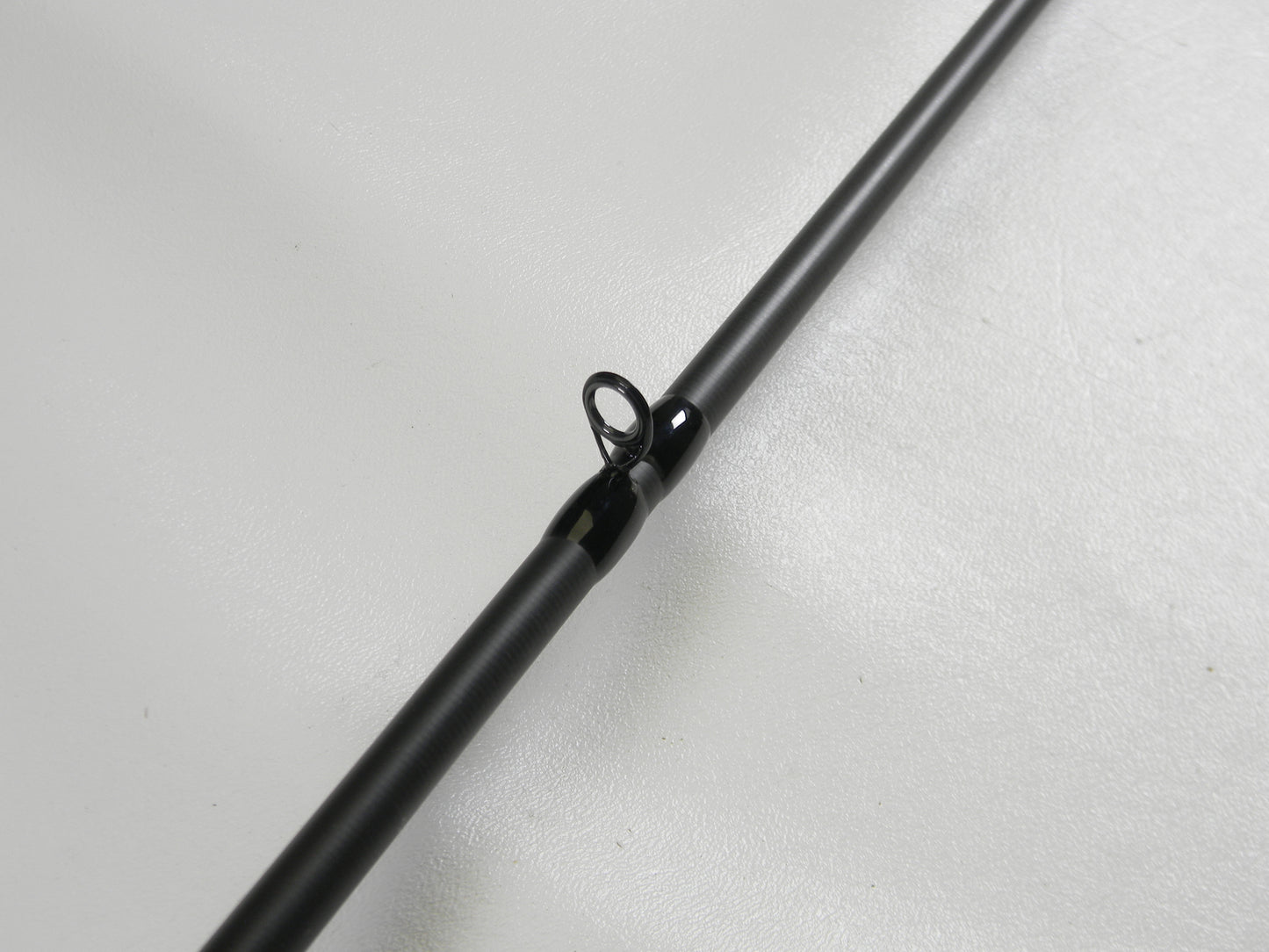 A close-up of the Dobyns Fury FR734C 7'3" Heavy casting rod against a white background highlights the intricate detail of one guide, featuring a black ring and mounting. Upgrade with our Rod and Reel Trade-In Program to earn store credit for your used gear.