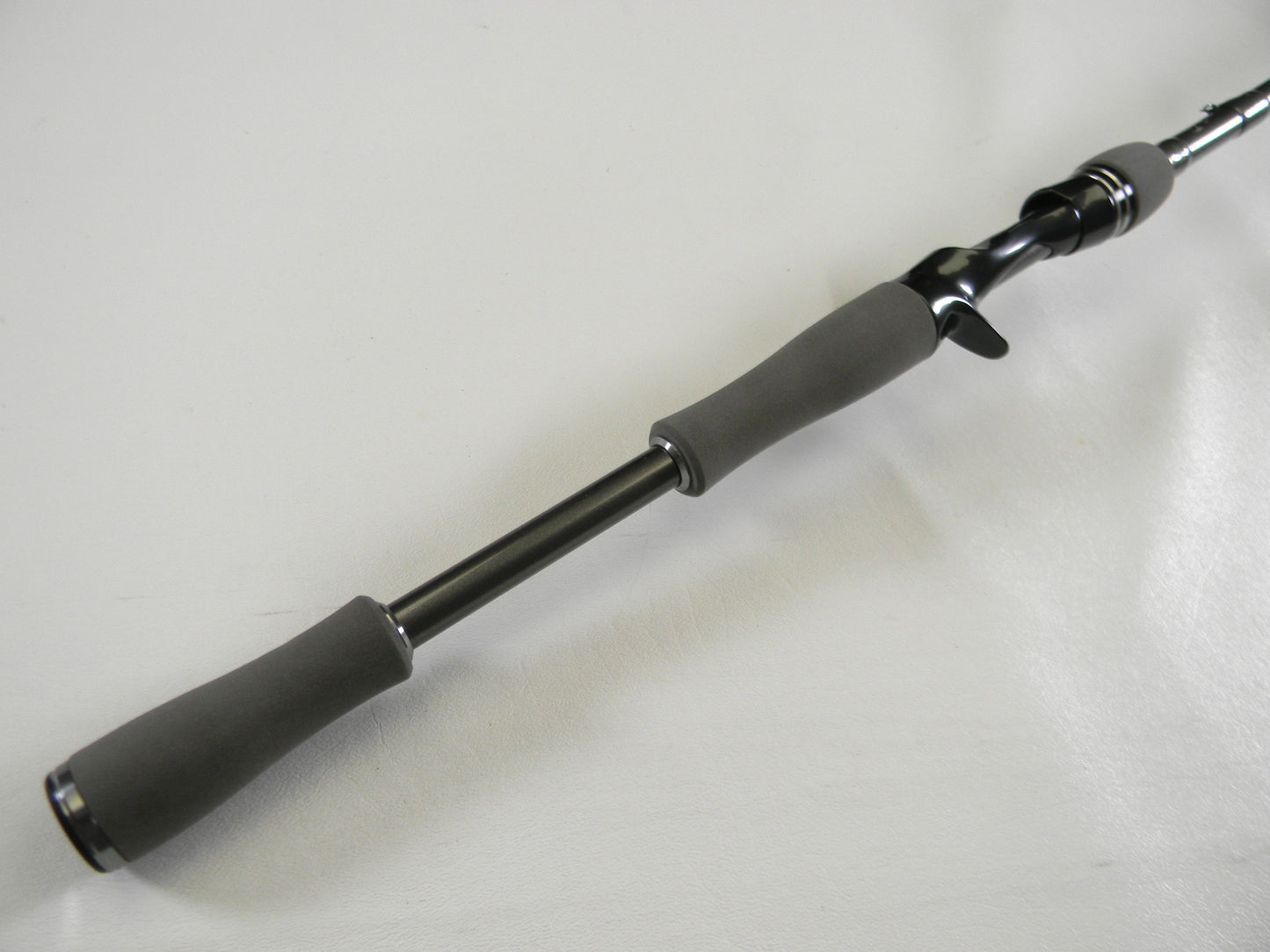Close-up of a Daiwa Tatula Elite TTEL761MHRB, a sleek 7'6" medium-heavy casting rod with black and gray handle and grip, set against a plain white background. Ideal for our Rod and Reel Trade-In Program to upgrade gear and earn store credit.