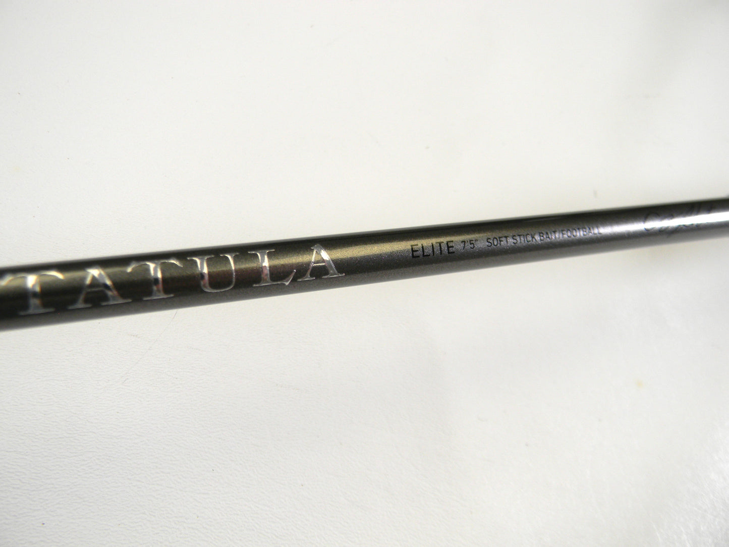 Close-up of a Daiwa Tatula Elite TTEL751MHFB fishing rod with metallic branding, featured in our Rod and Reel Trade-In Program. Its sleek dark finish on the 7'5" medium heavy rod is highlighted against a plain white background, showcasing its premium design.