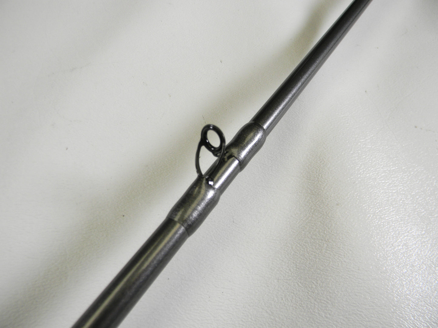 Close-up of the Daiwa Tatula Elite TTEL751HFB, a 7'5" heavy casting rod in mint condition, featuring a metal guide loop on its shaft against a white background. Ideal for upgrading through our Rod and Reel Trade-In program.