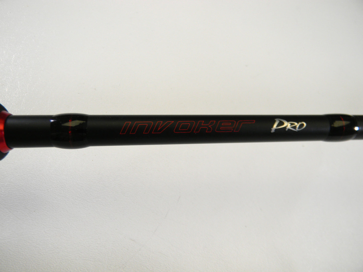 Close-up of a black Ark Fishing rod, model Invoker Pro IVP71MXS 7'1" Medium, with red and white lettering on a white background. Upgrade now with our Rod and Reel Trade-In Program to convert used gear into valuable store credit.