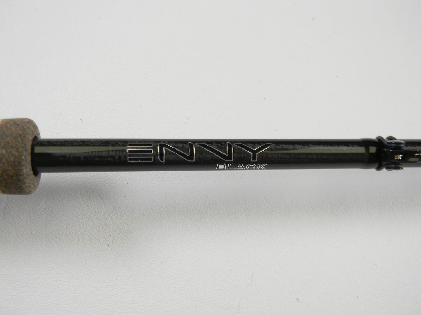 A close-up of a 13 Fishing Envy Black 3 EB3C68M 6'8" Medium Used Casting Rod in excellent condition, with silver "ENVY BLACK" lettering and a cork handle, shown against a white background. Eligible for our Rod and Reel Trade-In Program.