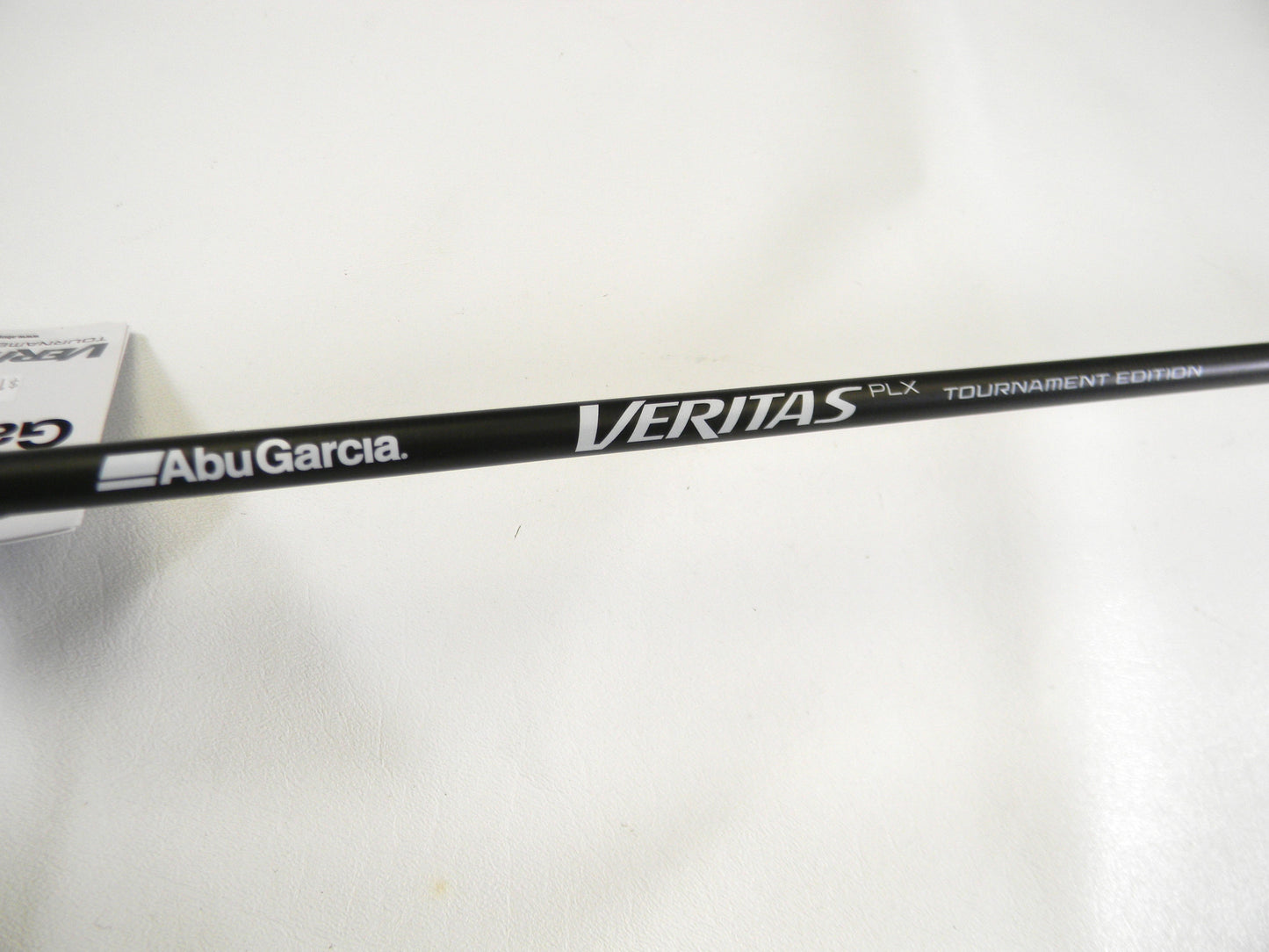 Close-up of a black fishing rod with "Abu Garcia" and "Veritas Tournament VXTC72-5" text on a white backdrop, ideal for our Rod and Reel Trade-In program for store credit.