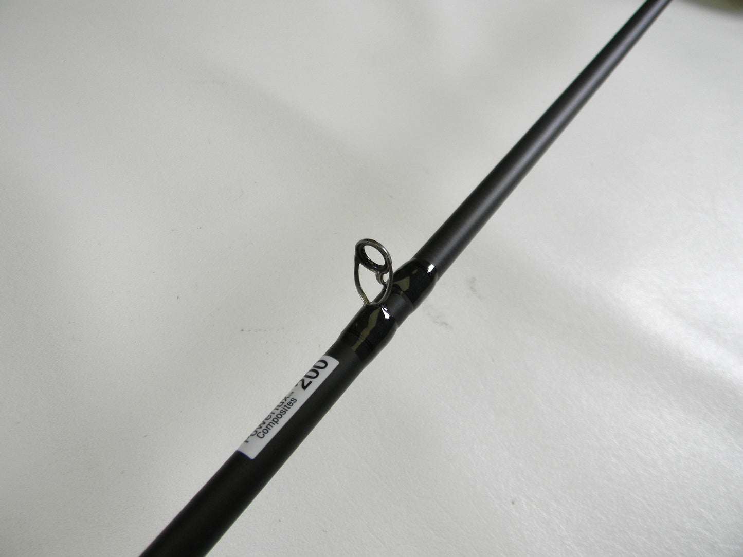 A close-up of the Abu Garcia Veritas Tournament VXTC72-5 7'2" Medium casting rod, featuring a line guide labeled "202" to signify its quality. This used gear, set against a light plain backdrop, qualifies for our Rod and Reel Trade-In program.