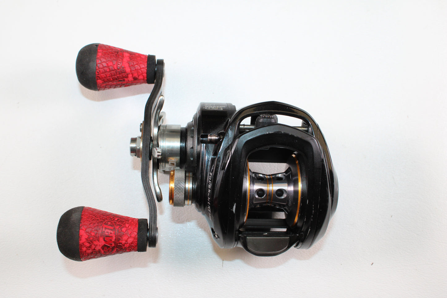 A Lew's Tournament MB LFS TS1SHMBL 7.5:1 LH used casting reel in good condition with black finish and red textured handle grips—great for upgrading via our Rod and Reel Trade-In Program or earning store credit for used gear.