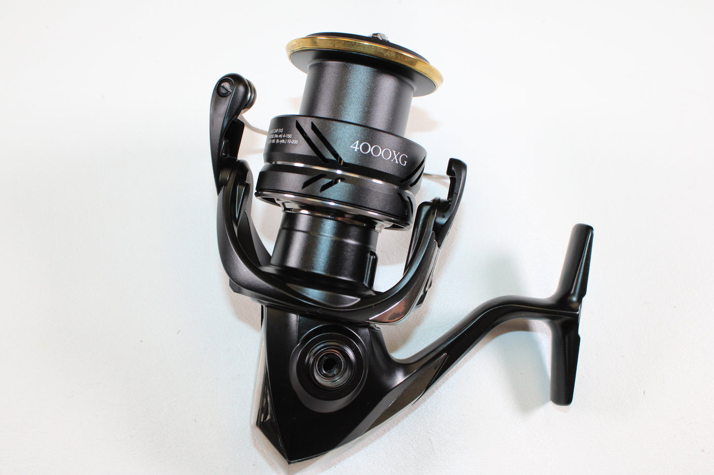 A close-up of the Shimano Sustain FJ SA4000XGFJ 6.2:1 Used Spinning Reel in Mint Condition, angled to display its handle and spool, perfect for trade-in or store credit. The black Shimano reel is set against a plain white background.