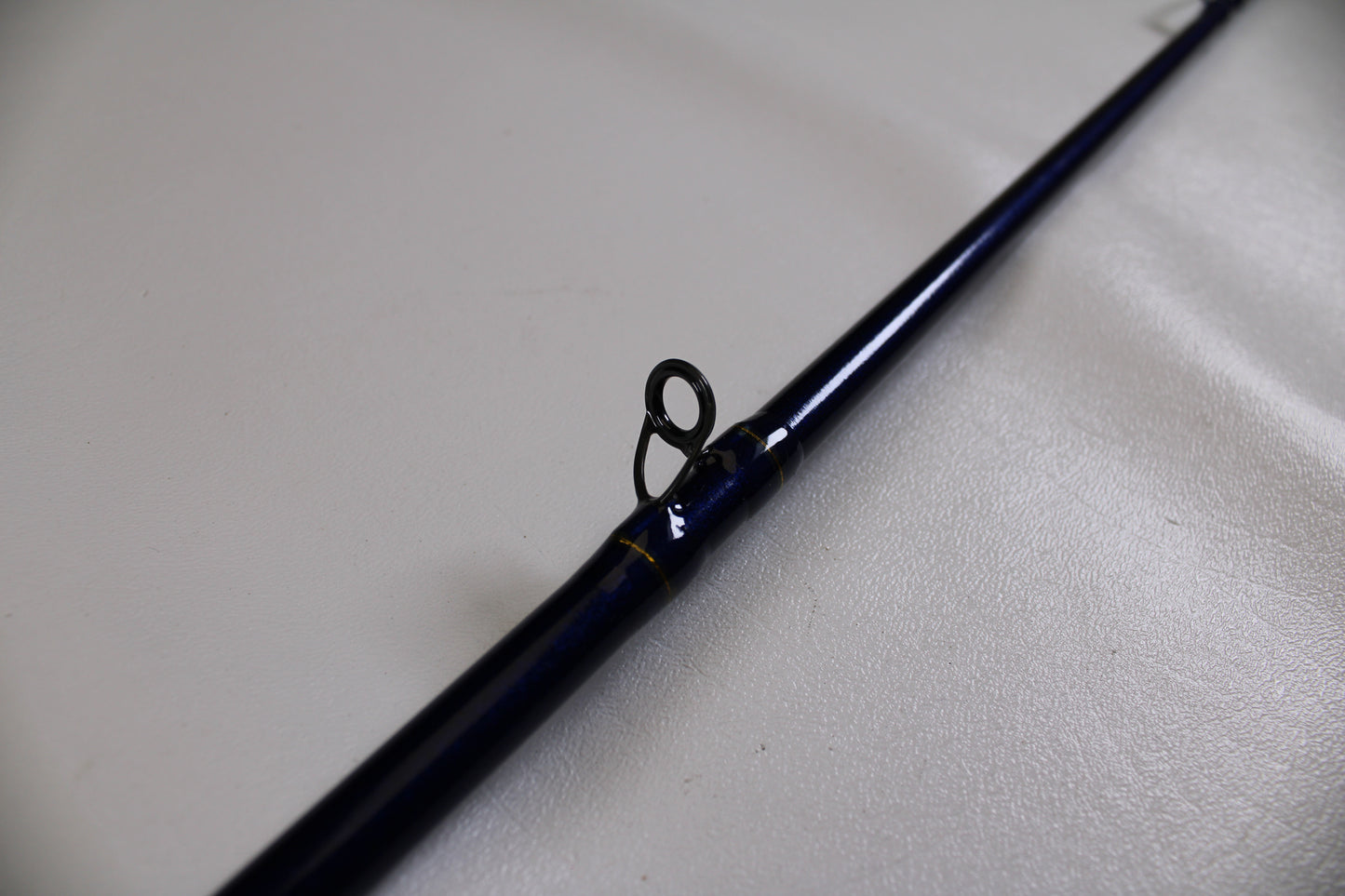 A close-up of the St. Croix Legend Tournament Bass LBTC74MHM Power Glass Cranker 7'4" Medium Heavy Used Casting Rod in excellent condition shows a single line guide ring, resting on a light surface—ideal for our Rod and Reel Trade-In Program.