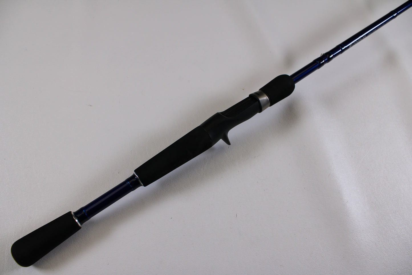 A close-up of the Douglas LRS C704M 7'0" Medium Used Casting Rod—excellent condition, shown diagonally on a white surface. Ideal for upgrading via our Rod and Reel Trade-In Program or shopping for top-quality used Douglas gear.
