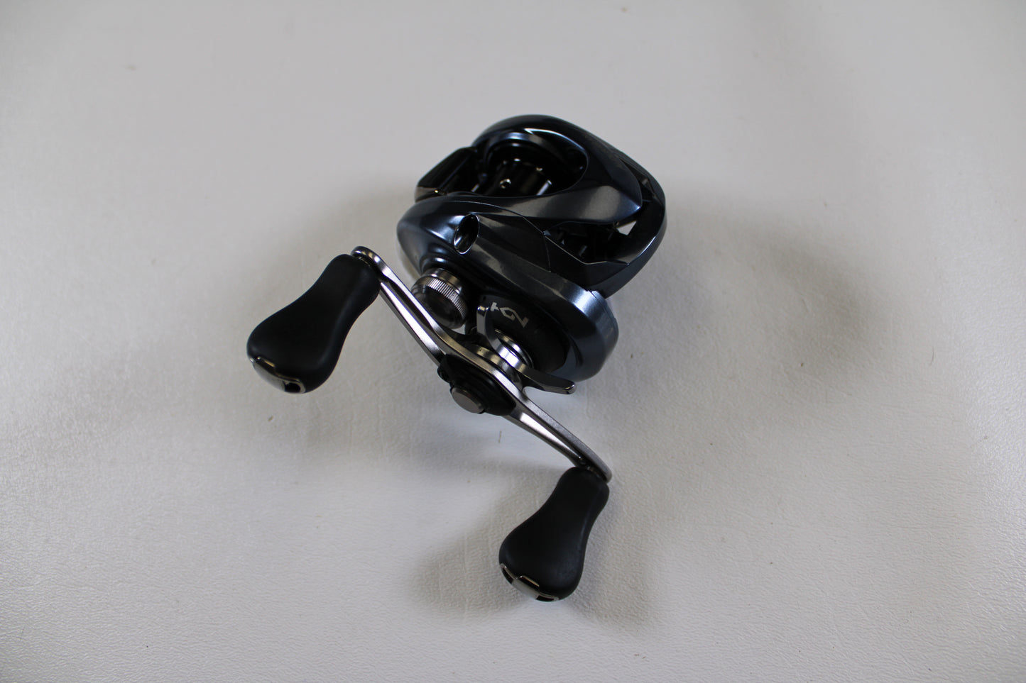 A Shimano Aldebaran MGL ALDMGL50HG used casting reel in excellent condition, featuring black and silver design and two handles, is displayed on a plain white surface—perfect for upgrading your gear or a Rod and Reel Trade-In.