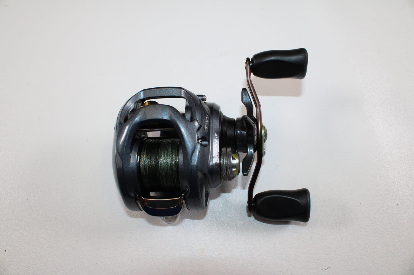 Upgrade with our Rod and Reel Trade-In Program or earn store credit on used gear—like this Daiwa Zillion SV TW JDM 9.1:1 Gear Ratio casting reel (used, good condition) by Daiwa, shown with black handles and green line on a white background.