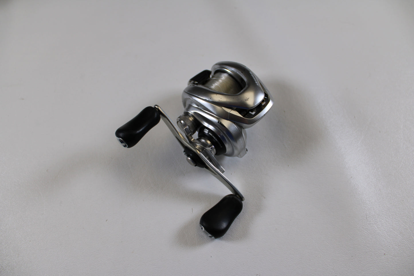A Shimano Metanium MGL 150 XG 8.5:1 used casting reel in good condition is displayed on a plain white surface, ready to be offered through our Rod and Reel Trade-In Program.