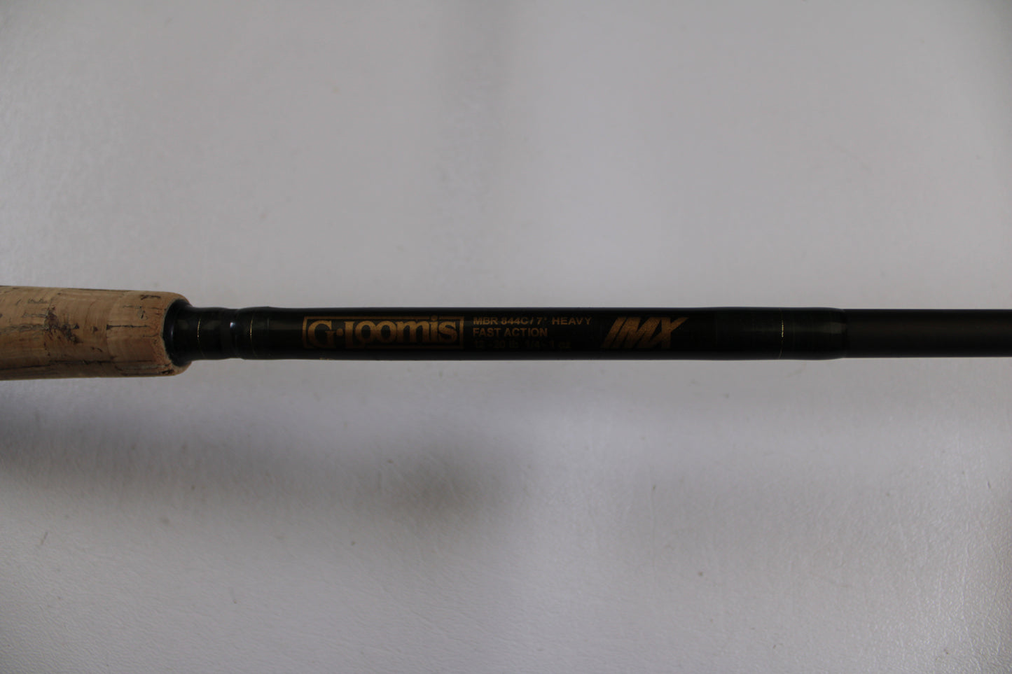 A close-up of the G. Loomis MBR844c IMX 7'0" Heavy Used Casting Rod in good condition, featuring a cork handle—ideal for those seeking value or trading up through our Rod and Reel Trade-In Program for store credit.