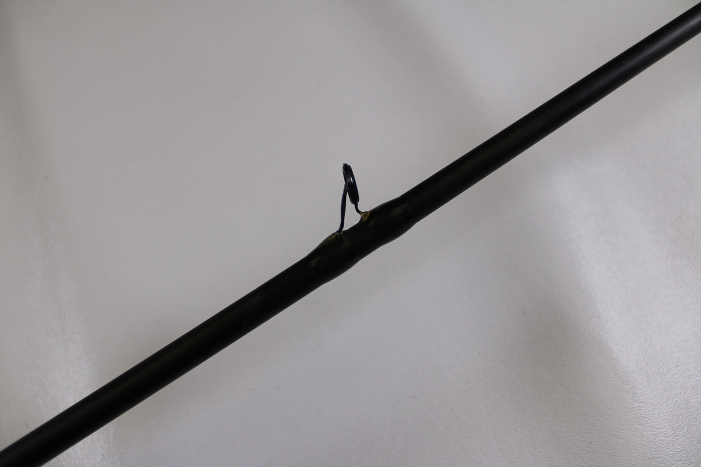 A close-up of the G. Loomis FSR904X IMX 7'6" Heavy Used Casting Rod in good condition, highlighting a line guide against a white background—ideal for featuring in a Rod and Reel Trade-In for store credit.