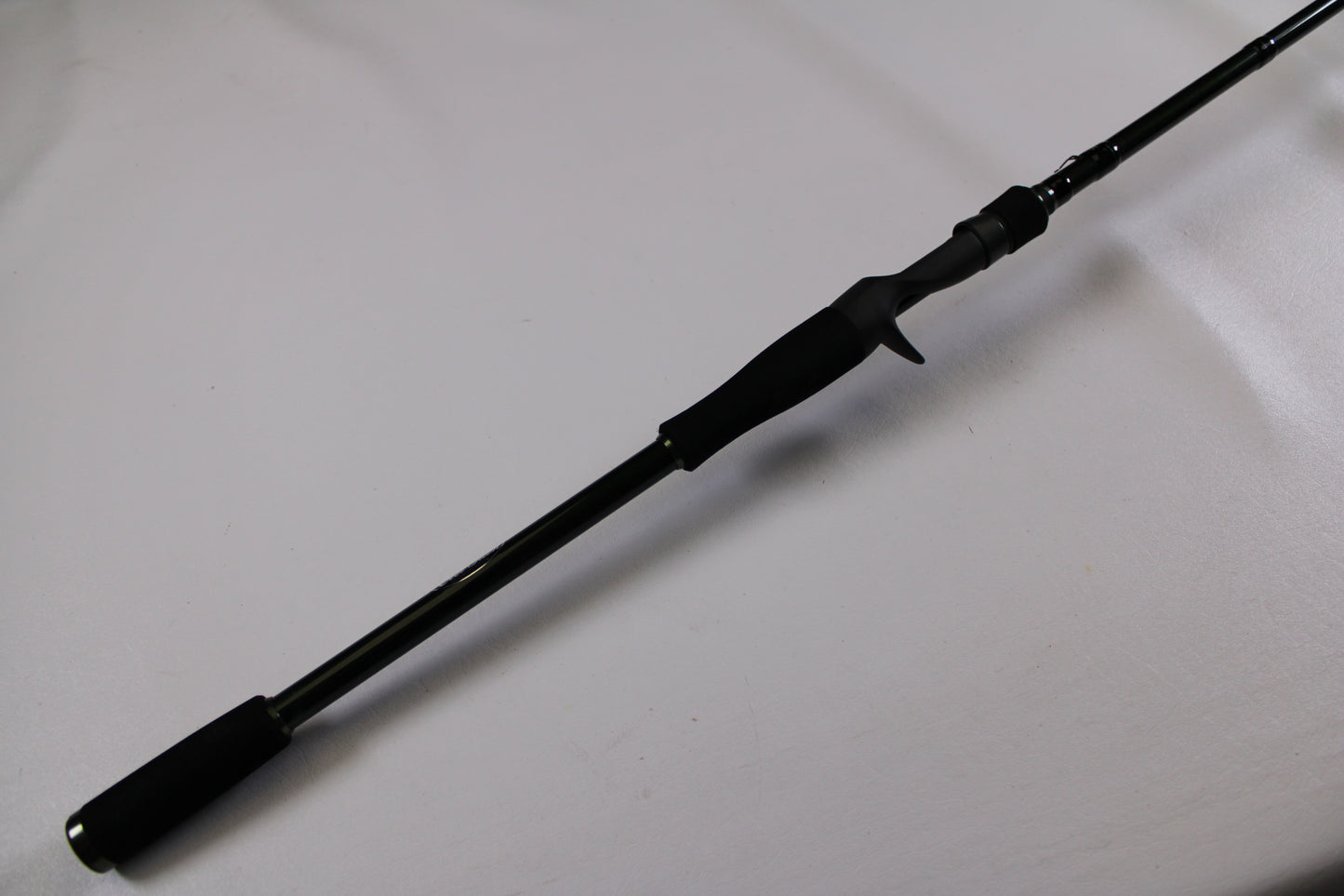 A close-up of the Evergreen Combat Stick RCTC-78XH used casting rod handle with trigger grip, shown diagonally on a white surface. Excellent condition—ideal for the Rod and Reel Trade-In Program.