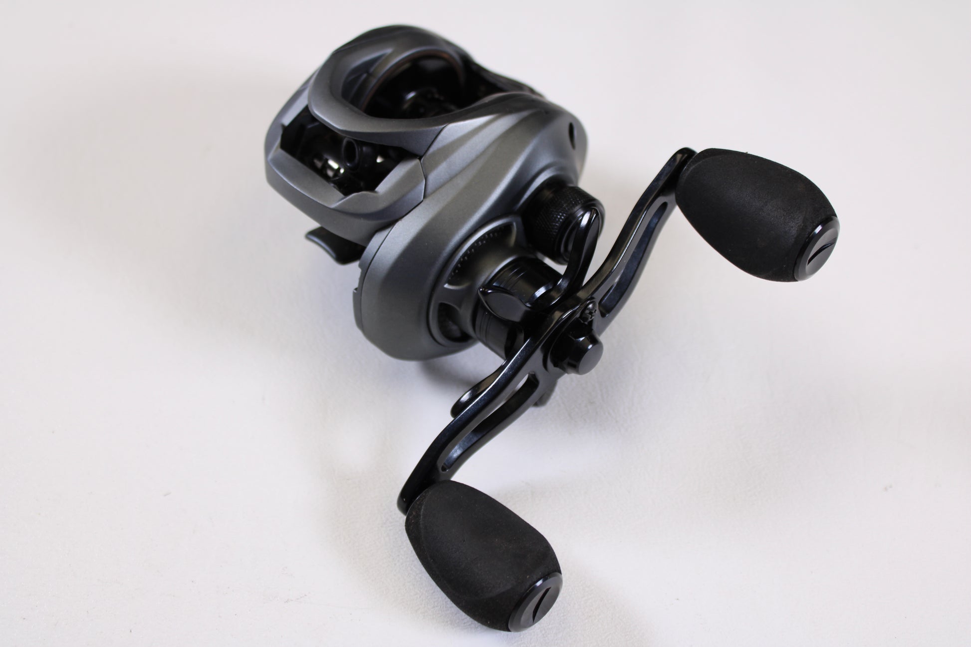 A close-up of the Fitzgerald VLD 10 FVLD-801L 8.1:1 LH—Used Casting Reel in very good condition, showing black and silver design with two large handle grips on a plain white background—ideal for upgrading your fishing gear.