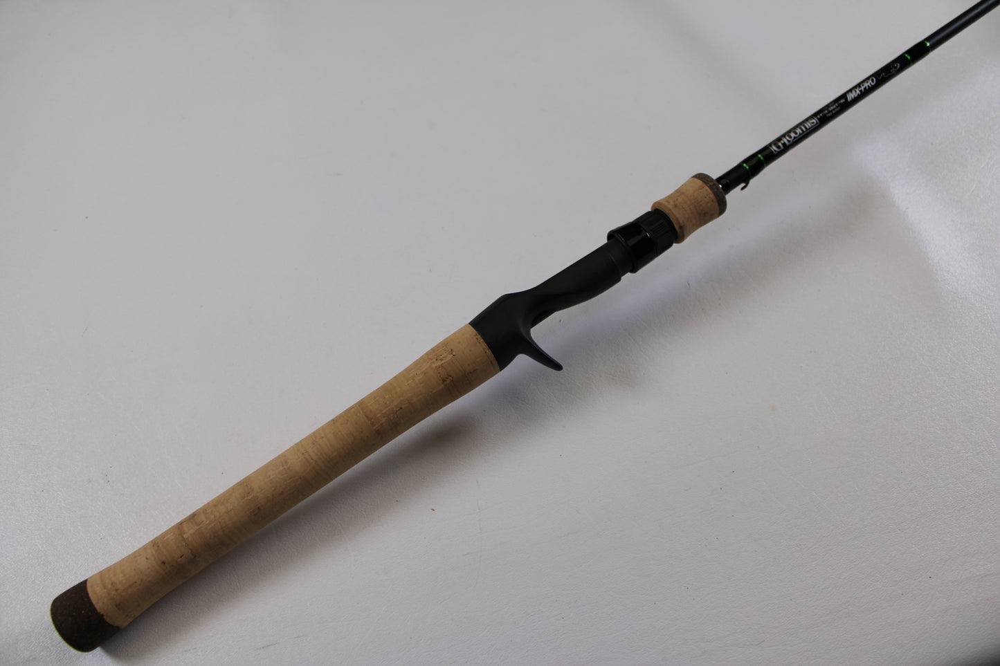 A close-up of the G. Loomis IMX-PRO 782c MBR 6'6" Medium Used Casting Rod in excellent condition, highlighting its cork handle and black reel seat—ideal for assessing used gear or our rod and reel trade-in program.