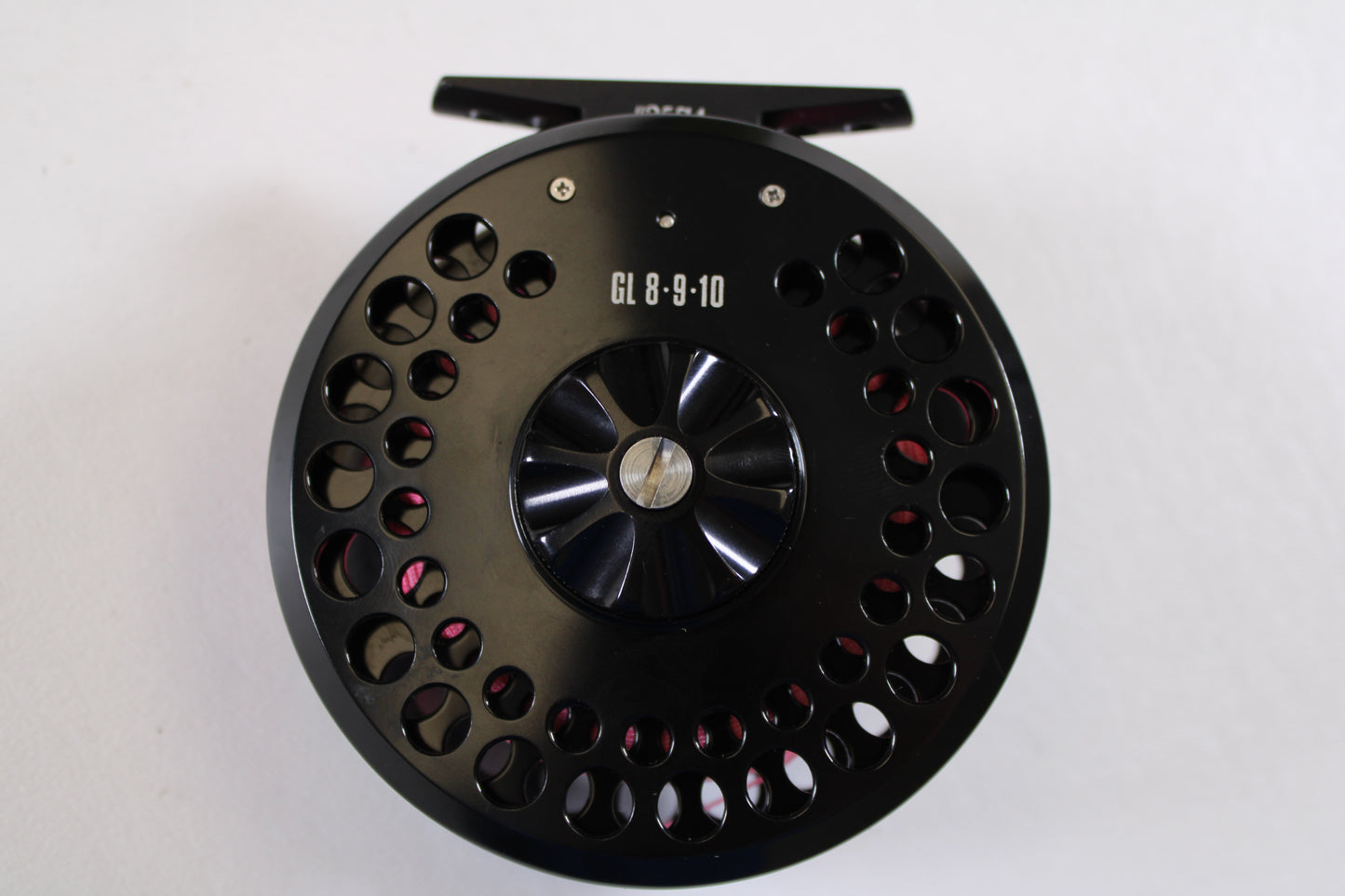 A close-up of a G. Loomis GL 8-9-10 with Spare Spool—Used Fly Reel in excellent condition, featuring multiple circular cutouts, photographed on a white background—ideal for our Rod and Reel Trade-In Program.