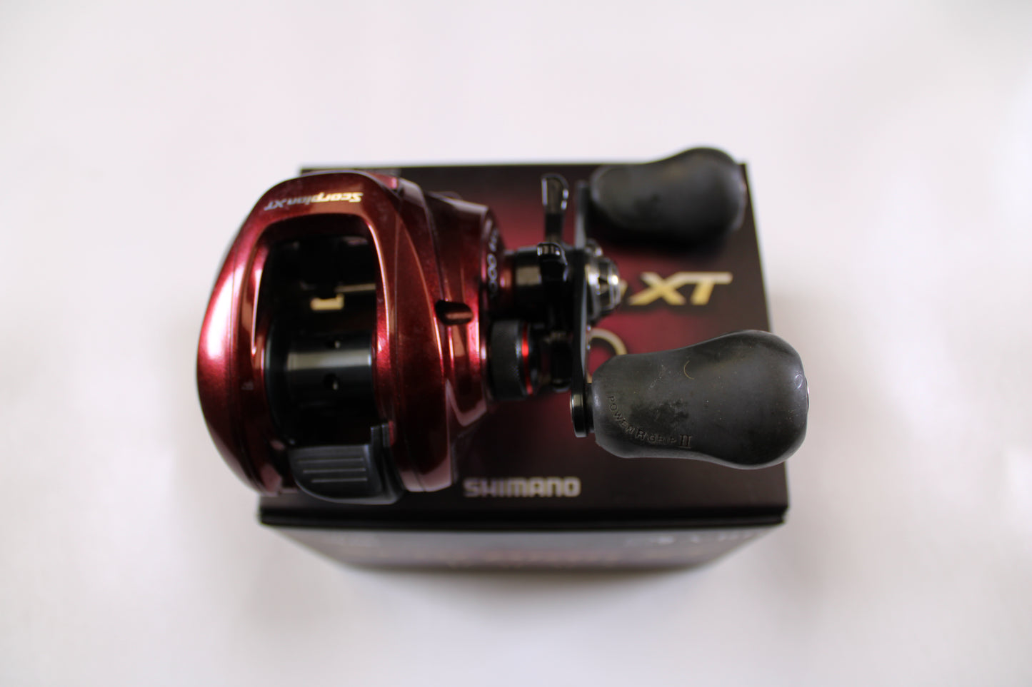 A Shimano Scorpion XT 1000 6.4:1 Used Casting Reel in very good condition is displayed on its black and gold XT box—ideal for upgrading through our Rod and Reel Trade-In Program.