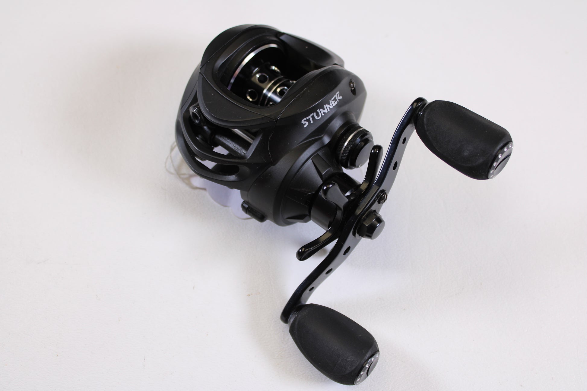 A Fitzgerald Stunner 6.3:1 LH used casting reel in excellent condition, featuring dual ergonomic handles, shown on a plain white surface—ideal for upgrades with our rod and reel trade-in program.