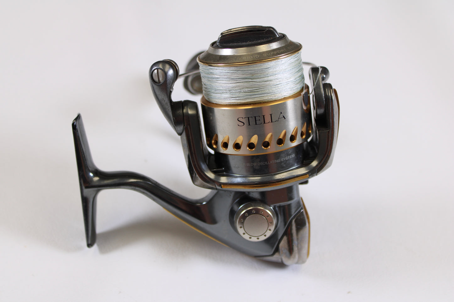 A close-up of a Shimano Stella FB 2500FB used spinning reel in very good condition, with fishing line on the spool, set against a white background—ideal for those interested in used gear or our rod and reel trade-in program.