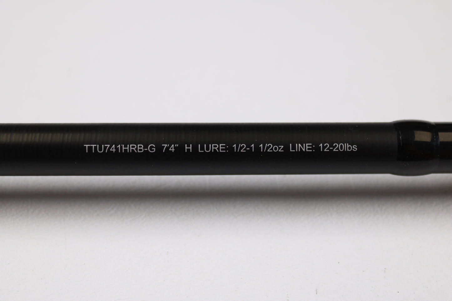 A close-up of the Daiwa Tatula TTU741HRB-G 7'4" Heavy Glass Used Casting Rod shows its specs in white text on a black rod, ideal for our Rod and Reel Trade-In Program if you're upgrading your used Daiwa gear.