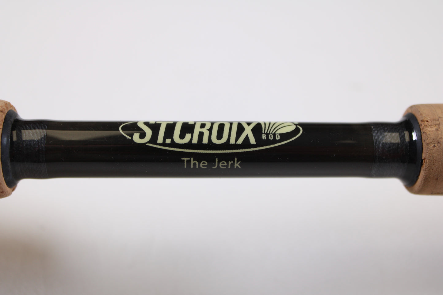 Close-up of the St. Croix Victory VTC68MXF "The Jerk" 6'8" Medium Used Casting Rod—very good condition, with logo and model name visible on the black rod between two cork handles—eligible for our Rod and Reel Trade-In Program.