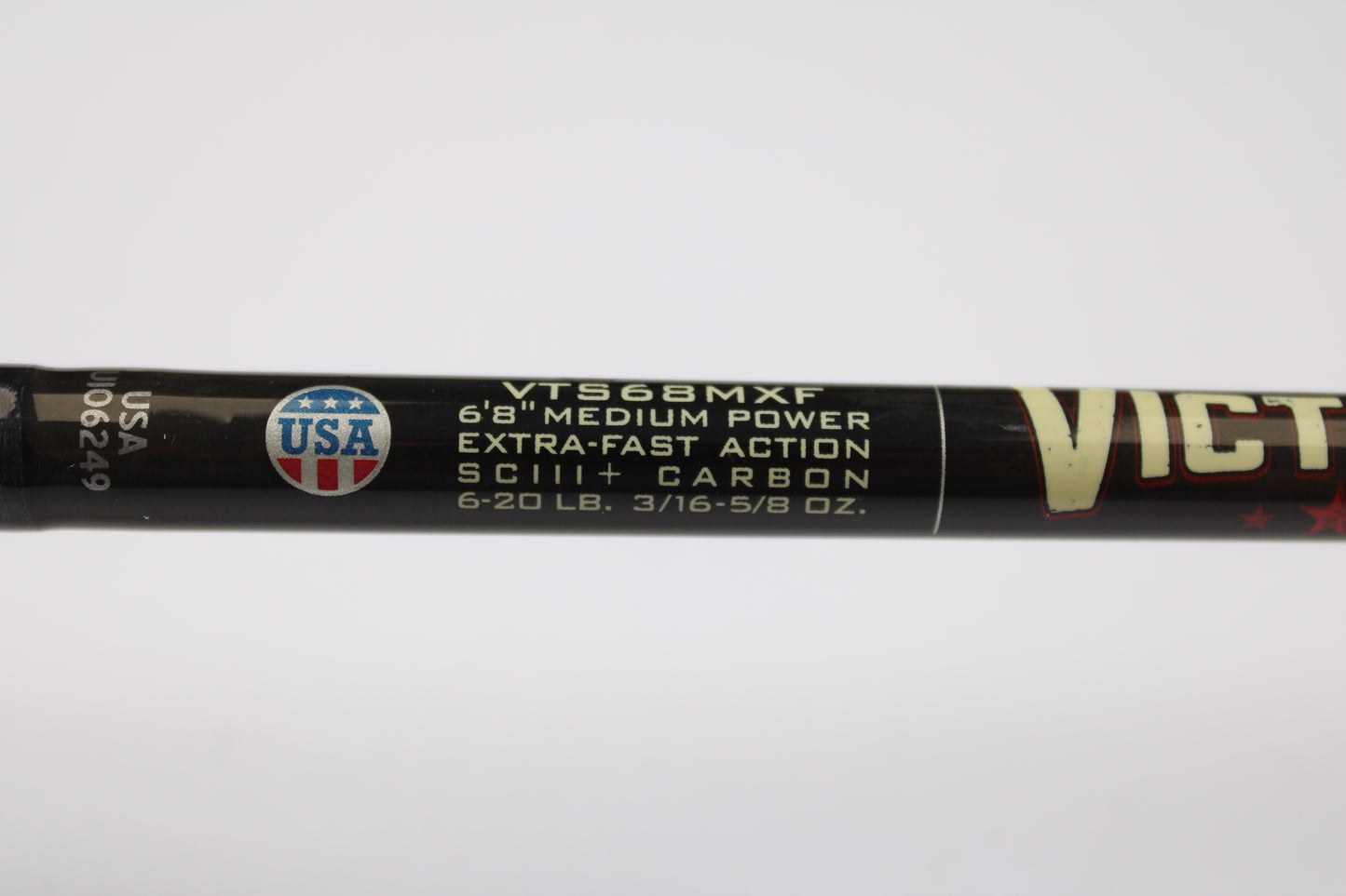 Close-up of St. Croix Victory VTS68MXF Tactical 6'8" Medium Spinning Rod label: extra-fast action, SCIII+ carbon, 6-20 lb line, 3/16-5/8 oz lure weight. USA emblem at left—eligible for our Trade-In Program for store credit on used gear.