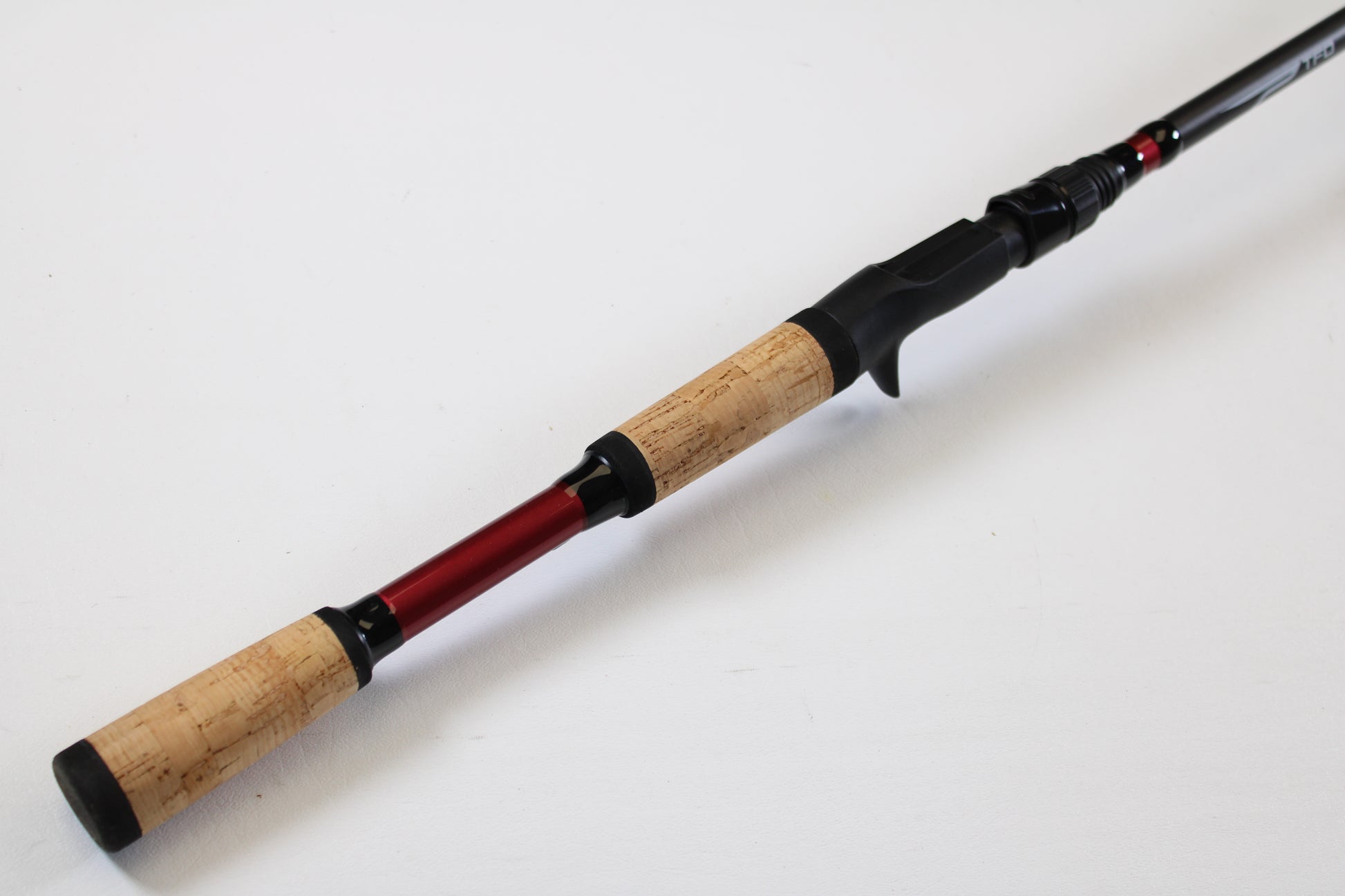 Upgrade with our Rod and Reel Trade-In Program: Temple Fork TFO Tactical Glass Bass TACGBCB745-1 7'4" Medium Heavy Used Casting Rod in excellent condition, featuring a cork handle and red accent, shown on a plain white background.