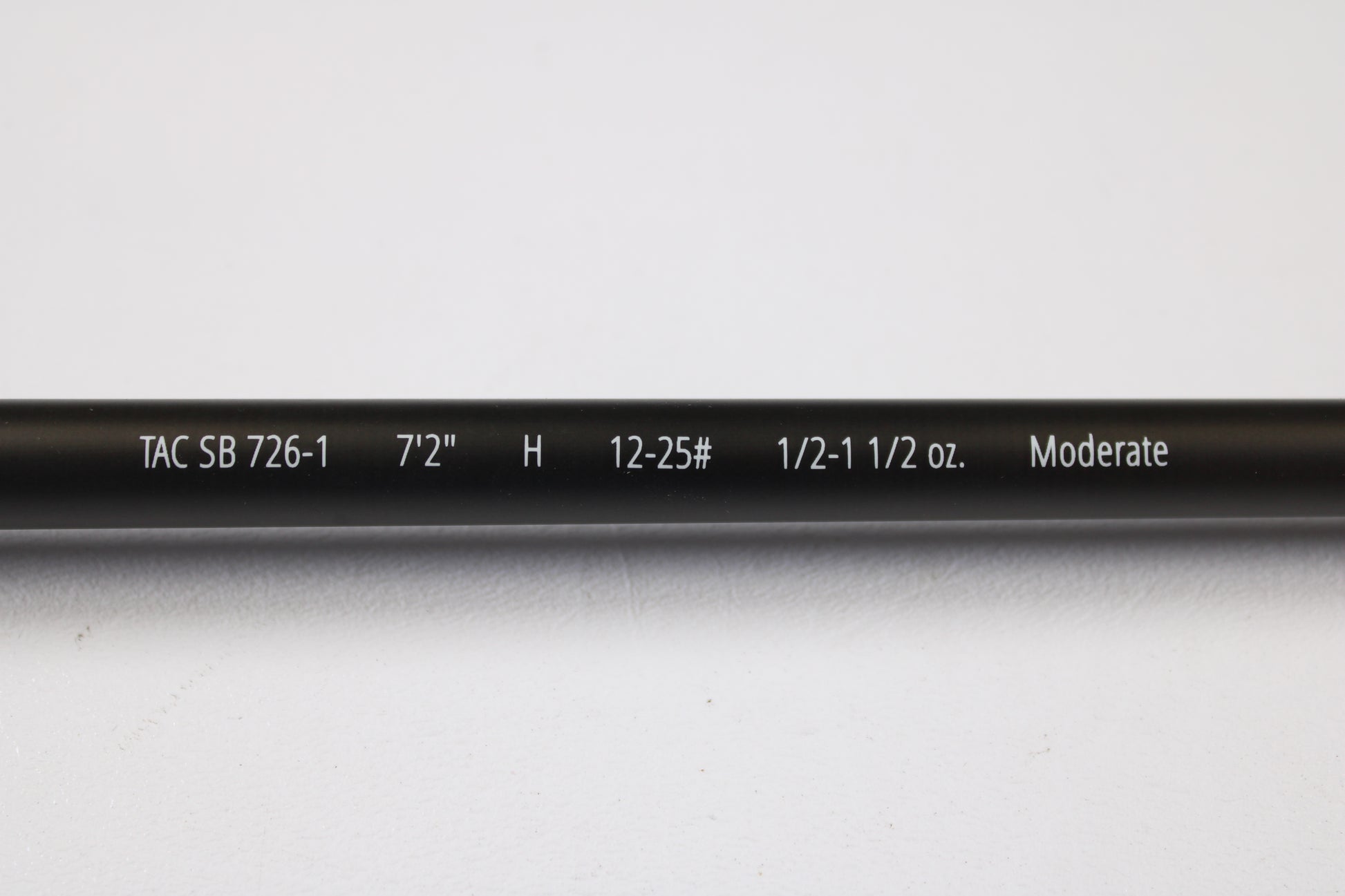 Close-up of a Temple Fork TFO Tactical Bass TACSB726-1 7'2" Heavy used casting rod in excellent condition, displaying its specs on the blank. Great for anglers seeking quality used gear or our rod and reel trade-in. Photographed on white background.