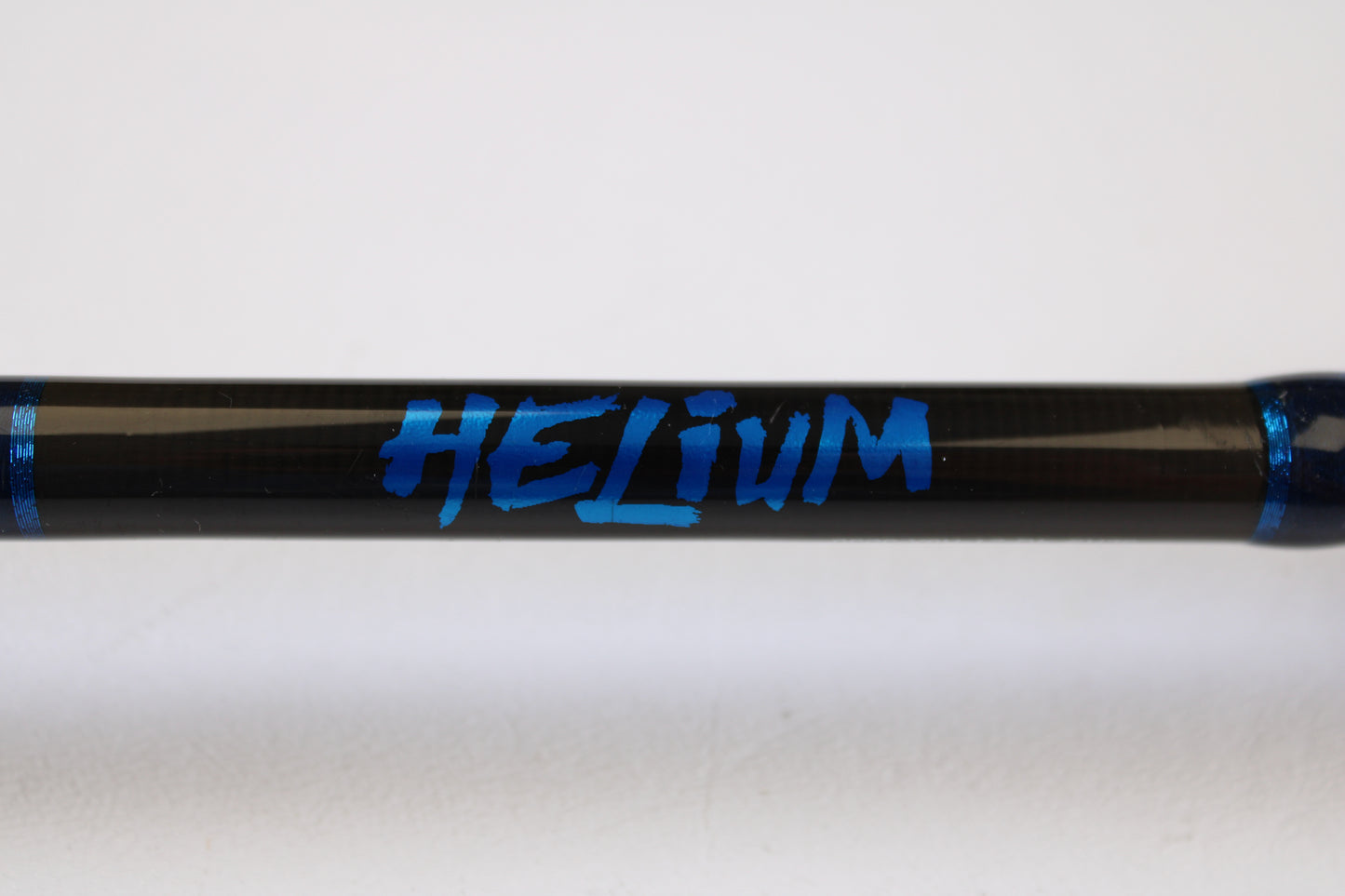 A close-up of a Kistler Helium HE703LMH 7'0" Lite Medium Heavy Used Casting Rod in excellent condition, featuring bold blue "HELIUM" graphics and blue bands—ideal for upgrading via our Rod & Reel Trade-In Program for store credit.
