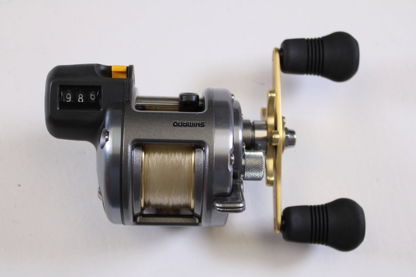 Close-up of a Shimano Tekota Line Counter 300LC TEK-300LC 4.2:1 RH used casting reel in excellent condition, with digital line counter and dual black rubber handles—ideal for your collection or our rod and reel trade-in program.