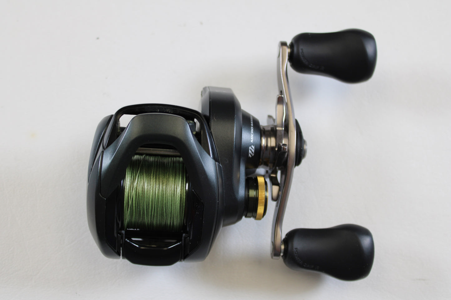 The Shimano Curado 200 K CU200HGK 7.4:1 RH Used Casting Reel—shown in excellent condition with green line spooled—is ideal for rod and reel trade-ins or those seeking top-quality pre-owned Shimano gear.