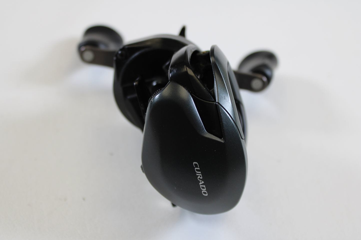 A close-up of a Shimano Curado 200 K CU200HGK 7.4:1 RH casting reel in excellent used condition, ideal for anglers upgrading with our rod and reel trade-in program.