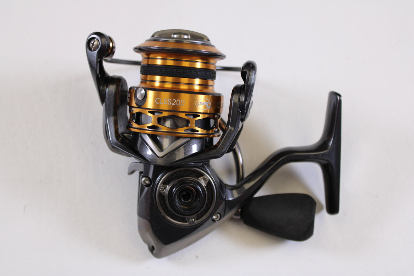 A close-up of the Lew's Custom Lite SS CLSS200 6.2:1 used spinning reel in black and gold, fair condition and missing handle nut—perfect for our Rod and Reel Trade-In Program when upgrading or trading for store credit.