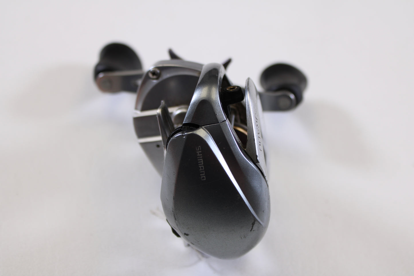 A close-up of a Shimano Curado I CU200I 6.3:1 RH used casting reel in good condition, shown in metallic grey with handle and spool on display—ideal for those trading in used gear or earning store credit.