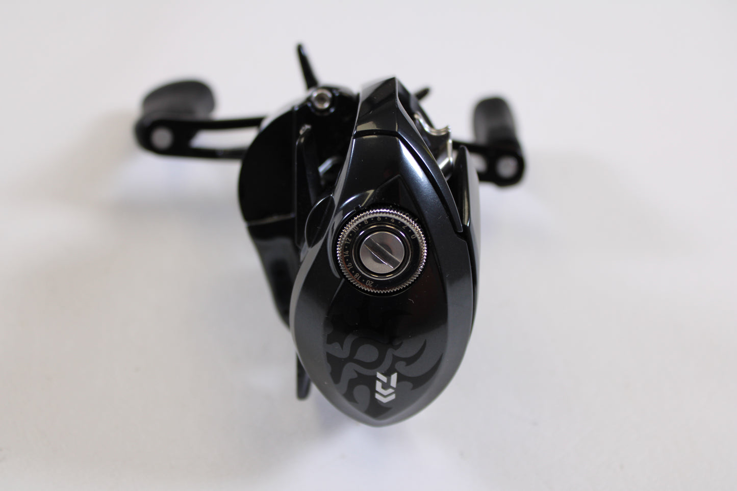 A close-up of the Daiwa Tatula SV TW 70 TTUSVTW70H 7.1:1 RH Used Casting Reel in excellent condition, featuring a black finish, silver adjustment knob, and ergonomic handles—ideal for quality rod and reel trade-ins or store credit.
